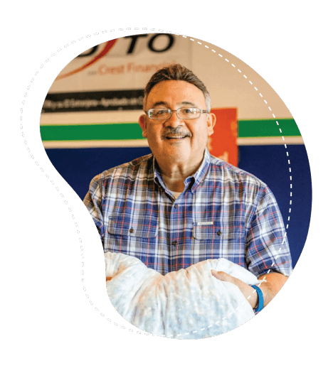 The owner of Mattress Clearance Warehouse holding a pillow